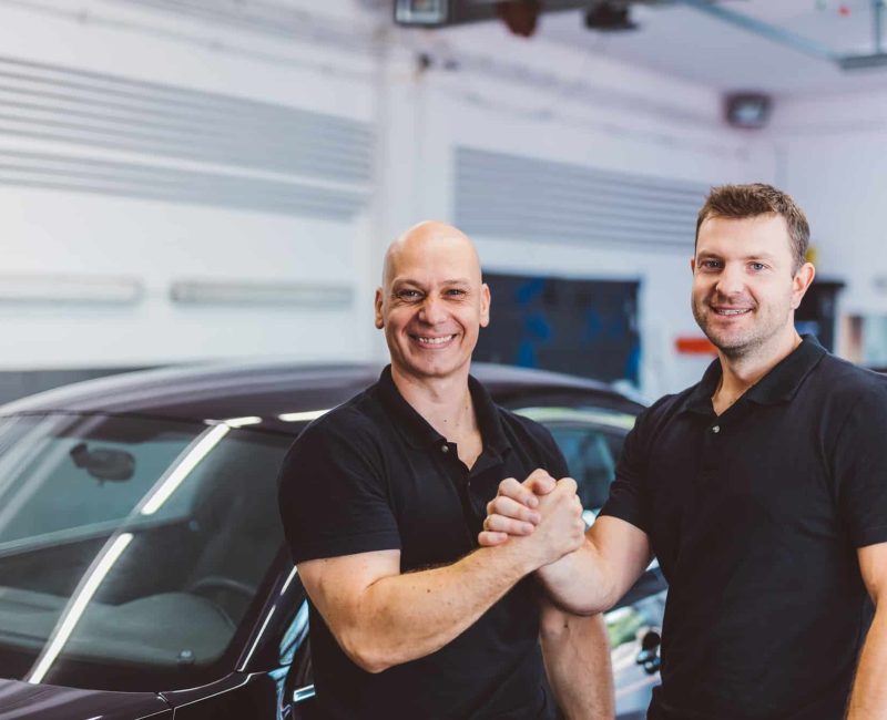 Car mechanics team in car detailing workshop, teamwork partners